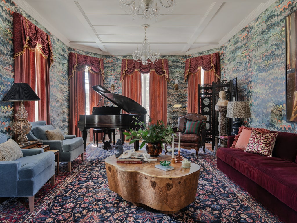 A colorful eclectic grand room with baby grand piano antiques and modern furniture.
