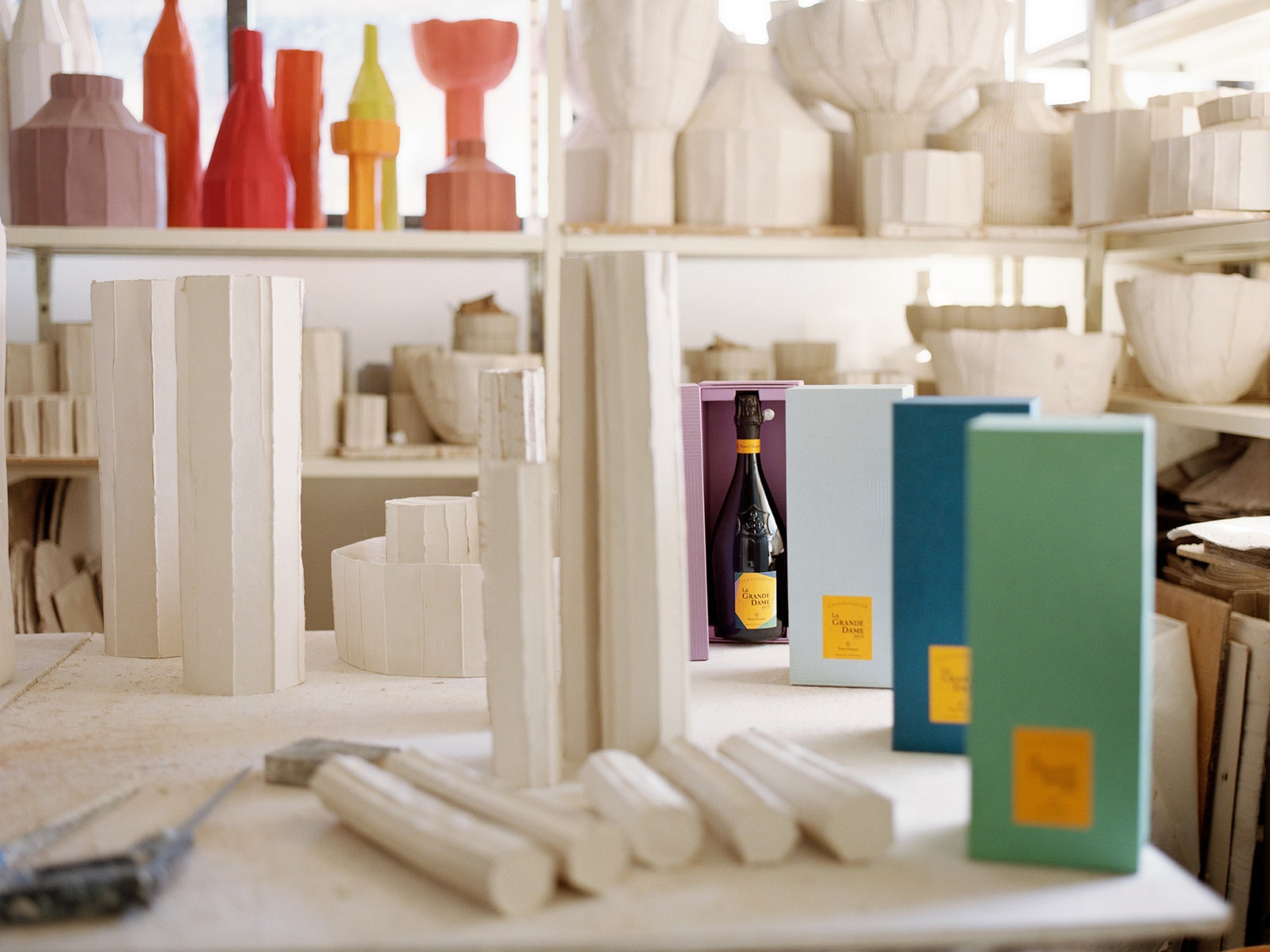 colorful champagne boxes on shelves alongside paperlike ceramics